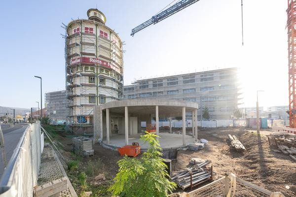Ein Turm ragt neben einer Baustelle in die Höhe.