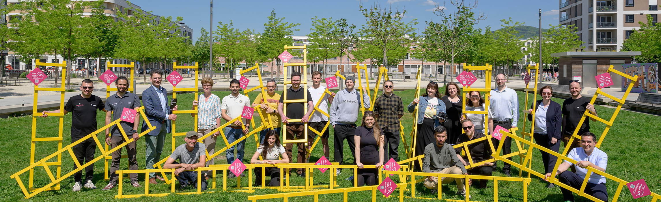 Lokale Unternehmen, die bei der Aktion mitmachen, auf einem Gruppenbild mit den gelben Leitern