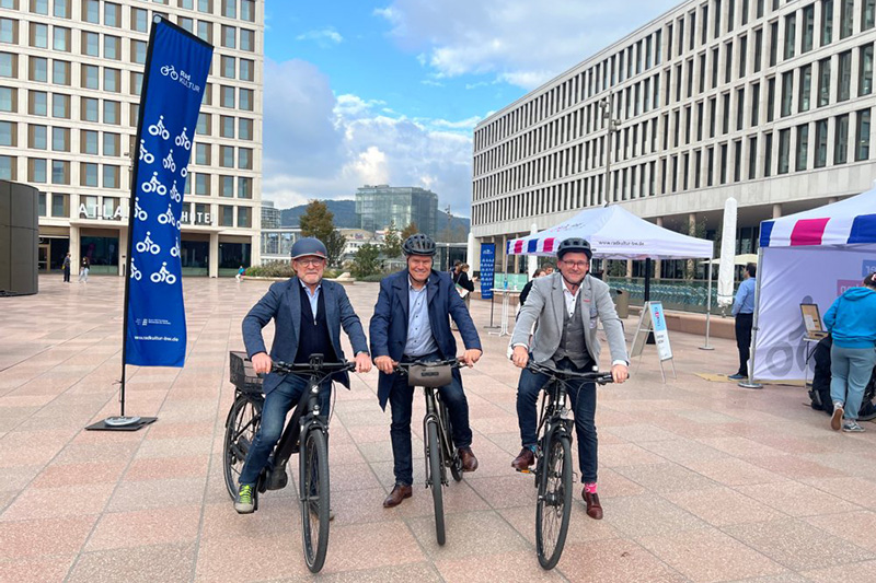 Zu sehen sind von links nach rechts: Winfried Herrmann, Verkehrsminister des Landes Baden-Württemberg, Oberbürgermeister Eckart Würzner und Mobilitätsbürgermeister Raoul Schmidt-Lamontain mit ihren Fahrrädern auf dem Europaplatz an der Südseite des Hauptbahnhofes  Süd