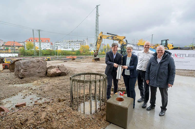 Vier Personen stehen auf einer Baustelle.